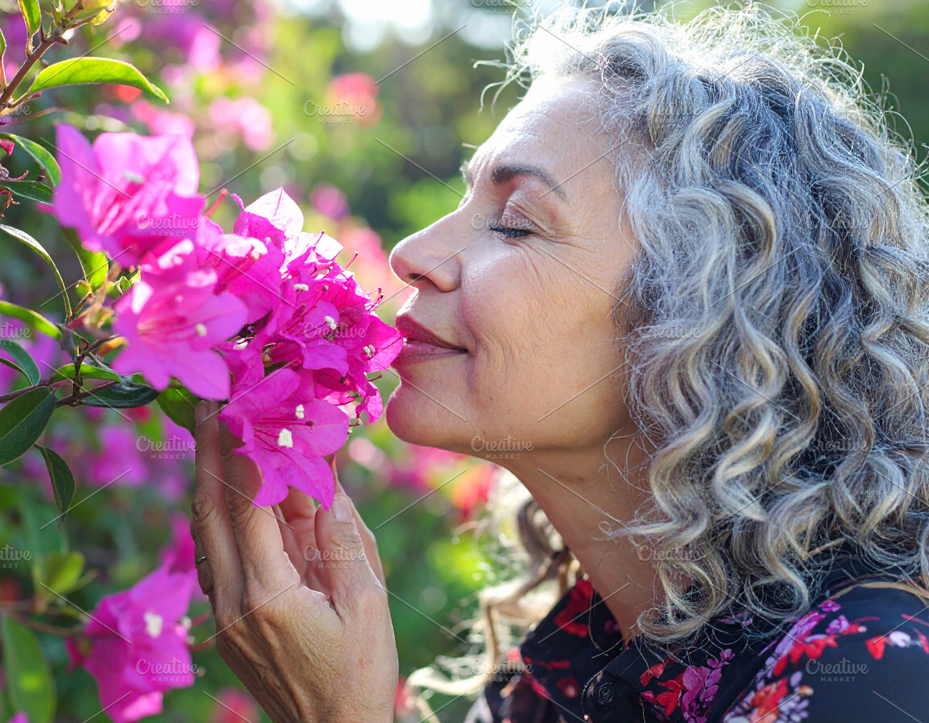 Profile of a woman smelling pink flowers, a Person Photo by DanFLCreativo