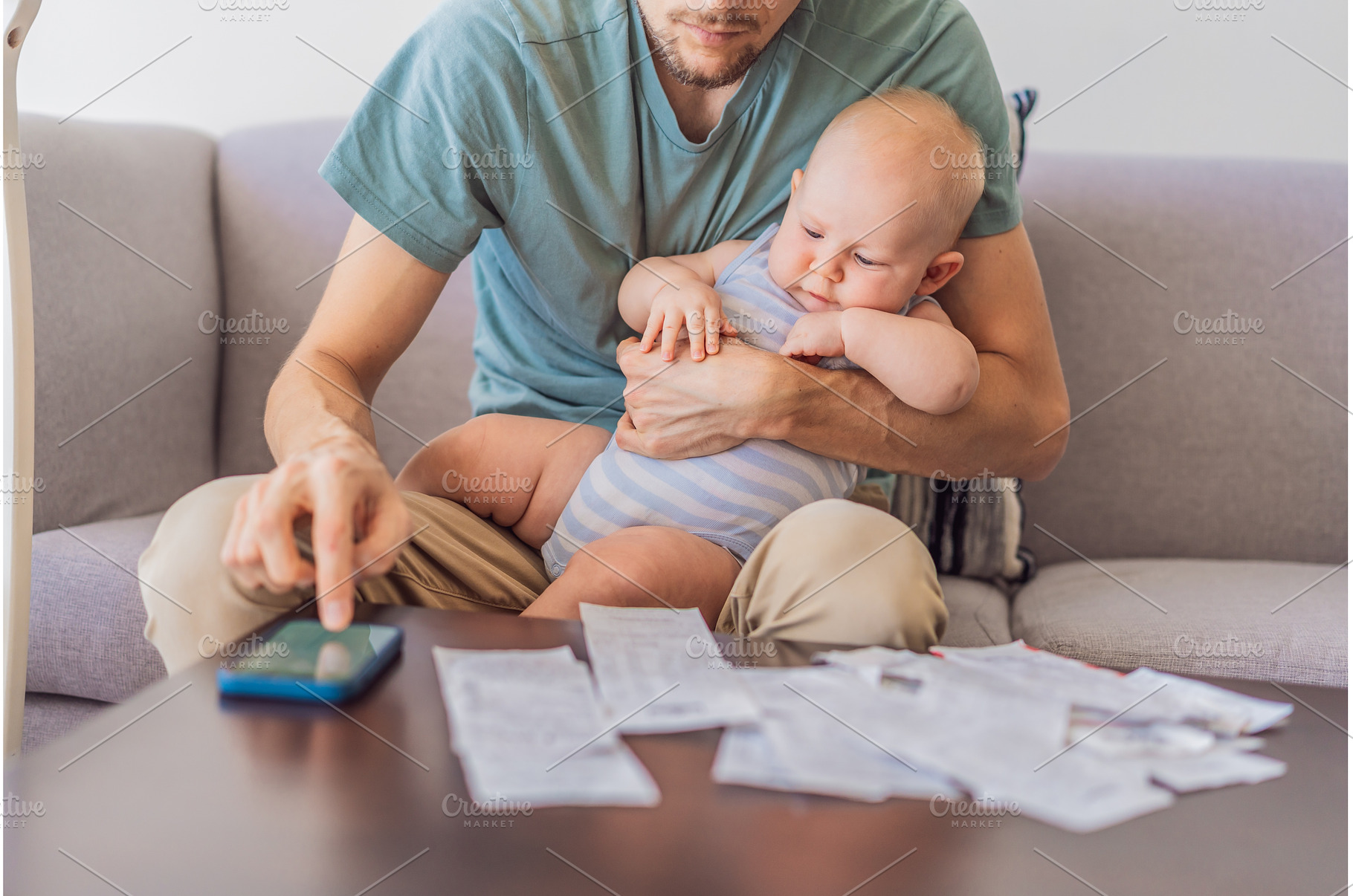 Father sitting on sofa holding baby, a Business Photo by Elizaveta Galitskaya