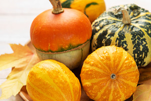 Decorative gourds pumpkins and autumn leaves on wooden tray, a Food & Drink Photo by Olena Rudo