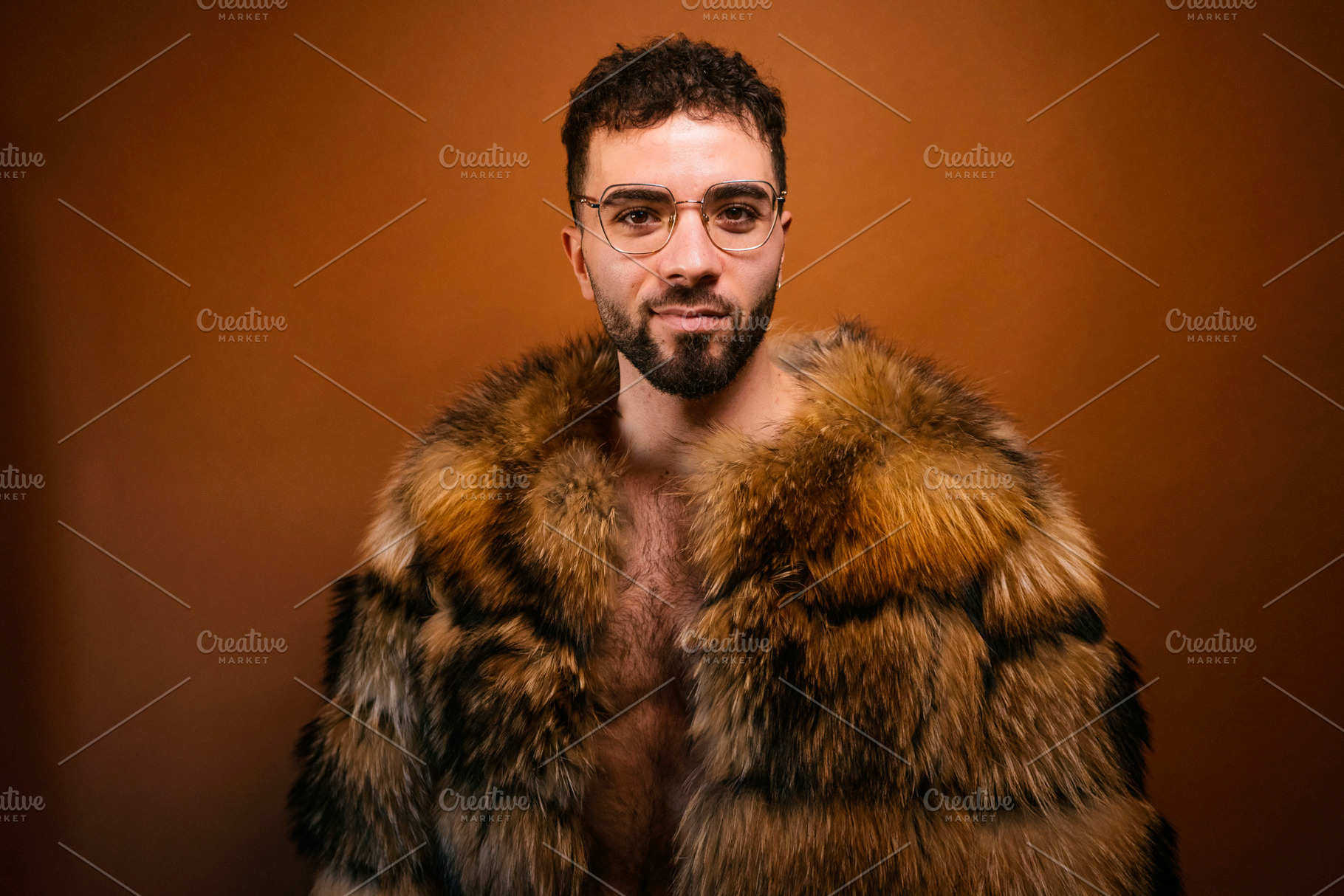 Confident man wearing stylish fur coat looking at camera, a Photo by karrastock