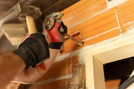 Man making a groove in the wall to put wiring, a Person Photo by Iván Moreno STOCK PHOTO