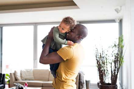 Young afroamerican father with his little daughter at home featuring african, a Person Photo by HalfPoint