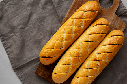 Homemade French Baguette with Garlic Filling on a wooden board,, a Food & Drink Photo by LiudmylaChuhunova