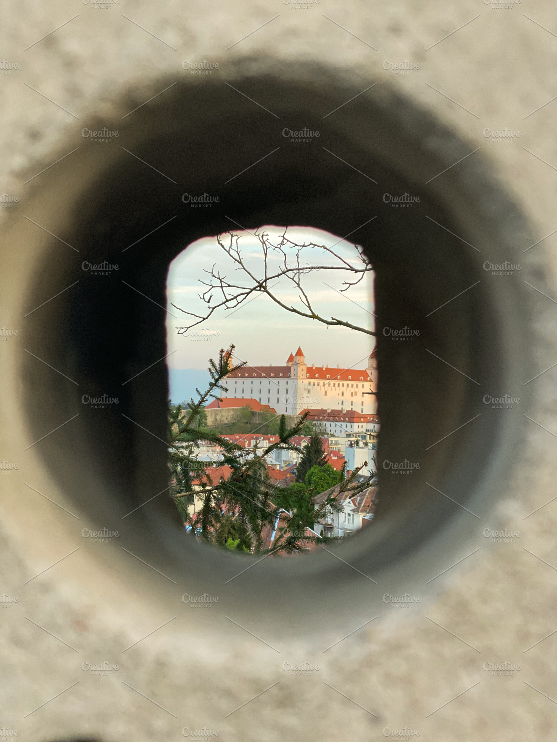 View of Bratislava Castle framed through a circular stone openin, a Holiday Photo by sebastianaraw