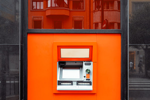 Modern ATM in orange wall panel, a Business Photo by SkyNext
