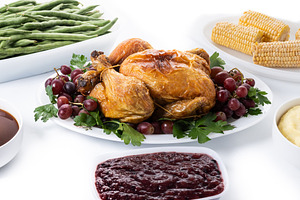Thanksgiving dinner on rustic wooden table with turkey,mashed potatoes,ears of, a Food & Drink Photo by etorres69