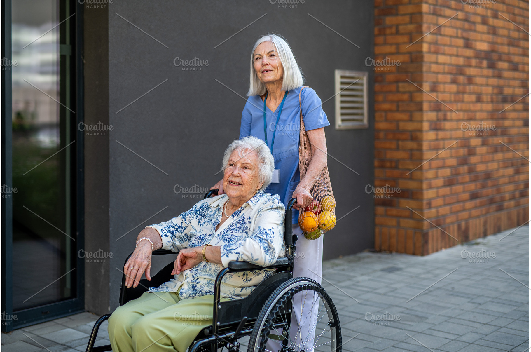 Home caregiver assisting older woman, a Food & Drink Photo by HalfPoint