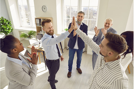 Happy colleagues giving high five at, a Person Photo by StudioRomantic