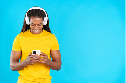 Latin man listening to music with, a Person Photo by Iván Moreno STOCK PHOTO