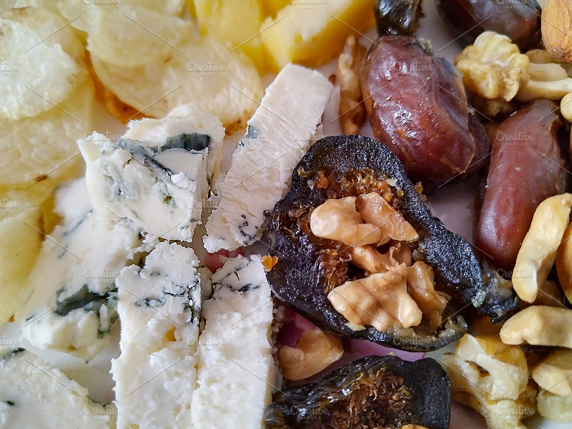Plate of food, including cheese, nuts, and other items., a Food & Drink Photo by DanFLCreativo