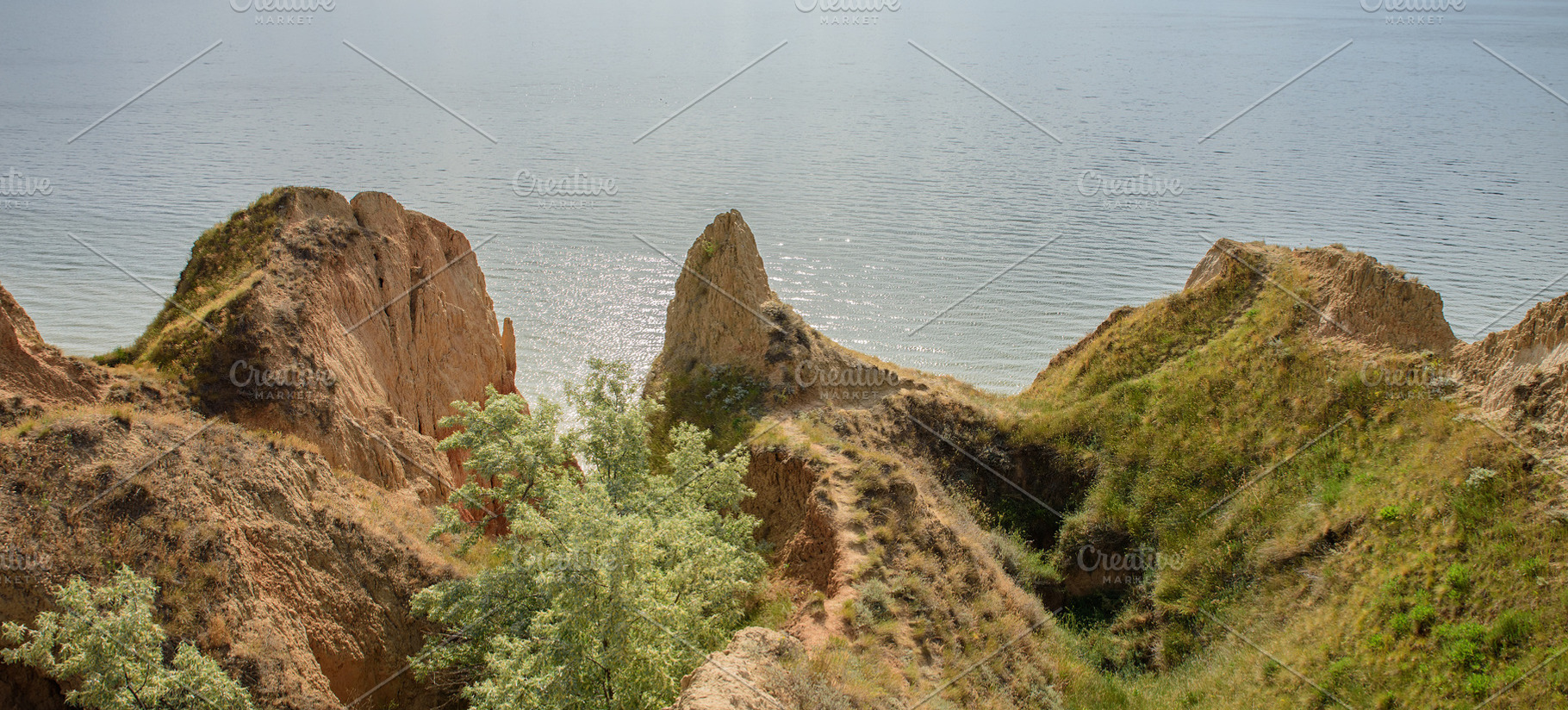 A panoramic view of steep clay cliffs covered with grass and shr, a Nature Photo by ndanko