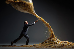 Determined businessman in suit pushing against a giant hourglass, an Abstract Photo by Ales Munt