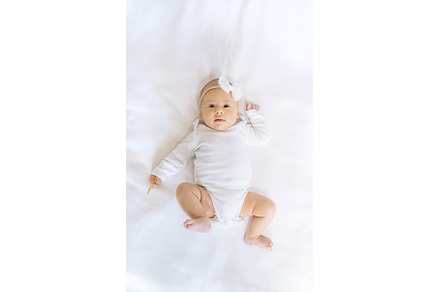 A newborn baby lies on a white bed, a Person Photo by yanadjana