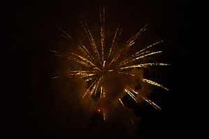 Fireworks exploding behind a wall of smoke