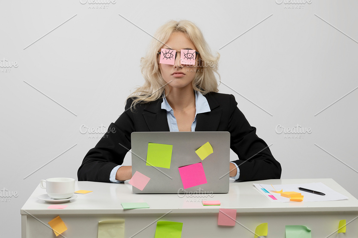 A lot of work concept. Tired young businesswoman having sleeping with stickers, a Photo by Prostock-Studio (Photo 2 of 2)