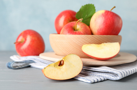 Bowl with apples on wooden background, close and space for text, a Food & Drink Photo by AtlasStudio