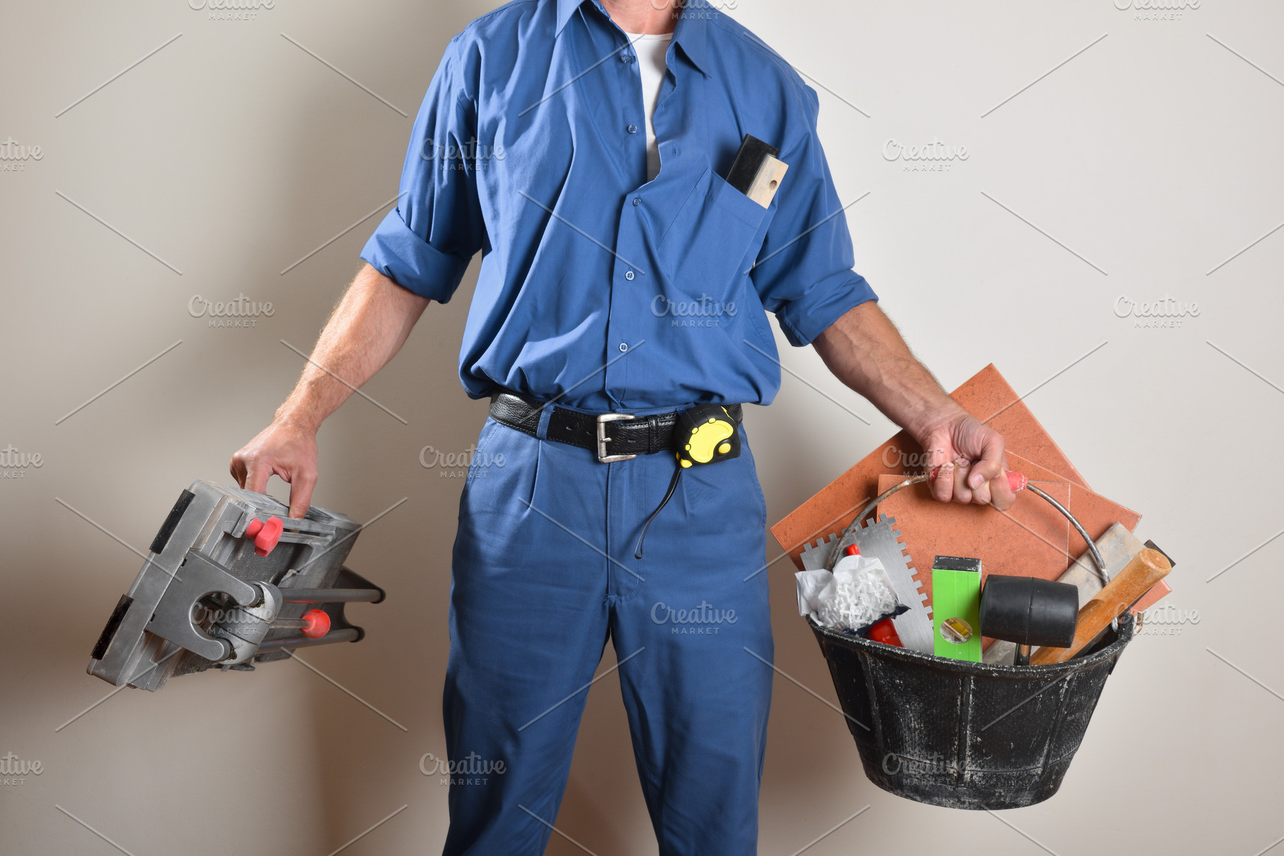 Tiler with ok gesture showing tools on wooden table, a Person Photo by Davizro's Market