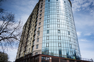 Modern glass and brick high rise building under a clear blue sky, a Photo by AS photostudio