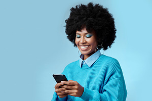 Mockup, smile and black woman with phone typing a online communication message to a contact using social media app. Retro, vintage and happy girl with afro hair doing a internet, web or online search, a Photo by Peopleimages.com
