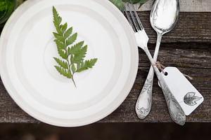 Rustic table setting featuring dish, plate, and green