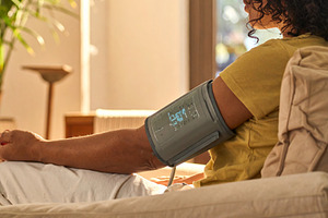 Blood pressure monitor placed on the arm of a person sitting in, a Person Photo by DanFLCreativo