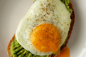 Homemade Avocado Toast with Egg on a Plate, top view. Close-up., a Food & Drink Photo by LiudmylaChuhunova