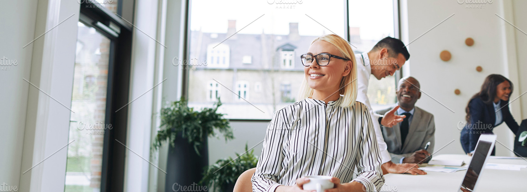 Smiling young businesswoman enjoying her coffee during an office, a Business Photo by Stefan & Janni