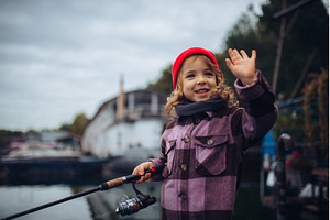 Child enjoying fishing outdoors, a Sports & Recreation Photo by HalfPoint