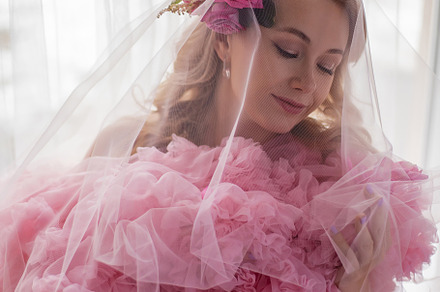 portrait of a fashionable blonde woman in a pink dress and rose flower in her h, a Person Photo by SaulichPhoto