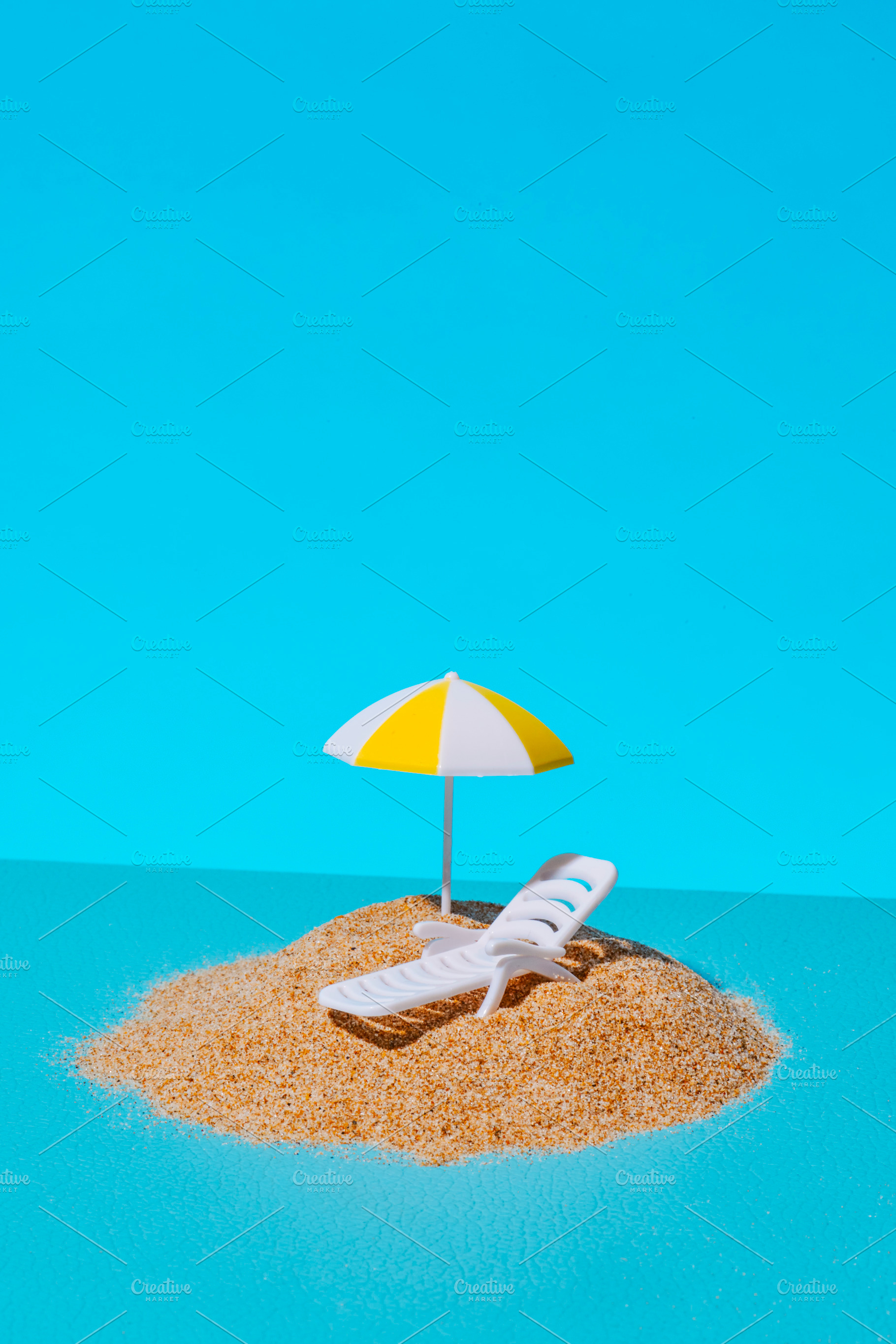 a miniature beach scene on a blue background, a Photo by Nito