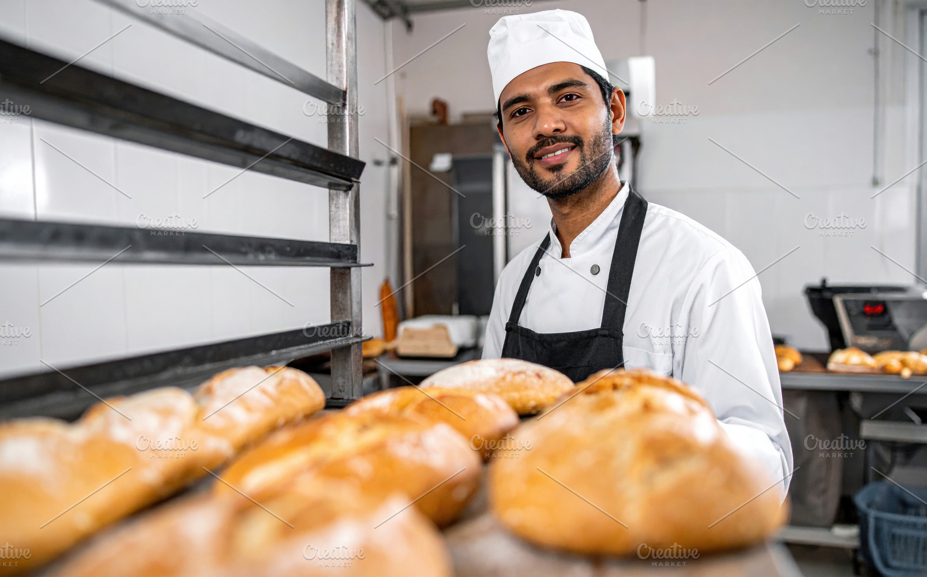 Young South Asian Baker Presenting Fresh Bread, a Food & Drink Photo by Davizro's Market