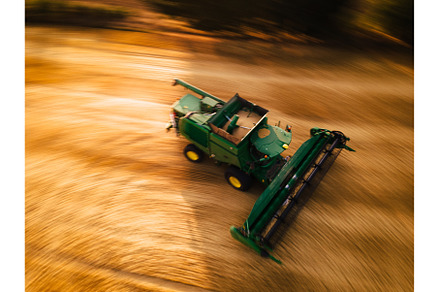Aerial view of a harvester working, an Industrial Photo by HalfPoint