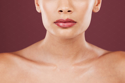 Face lips, makeup and beauty of woman in studio isolated on a red background. Skincare dermatology, lipstick cosmetics and female model with beautiful, glowing or healthy skin after facial treatment., a Photo by Peopleimages.com