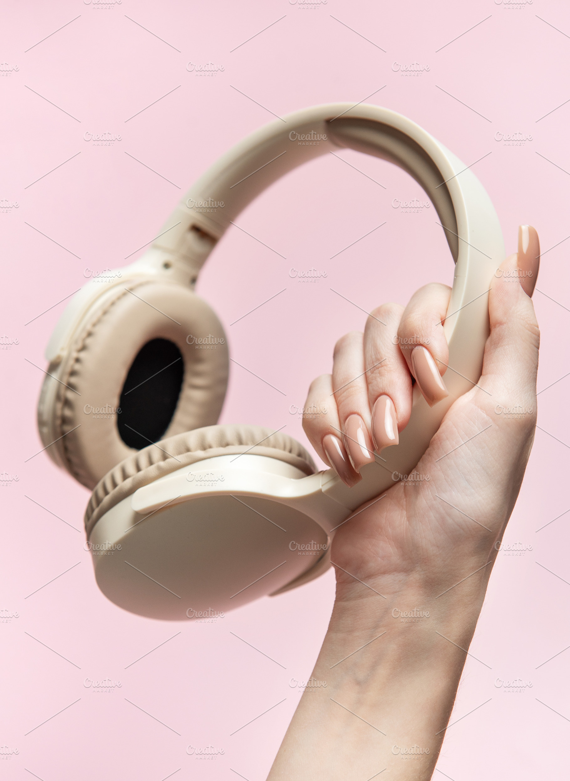 Woman holding wireless headphones on pink background, a Technology Photo by Olena Rudo