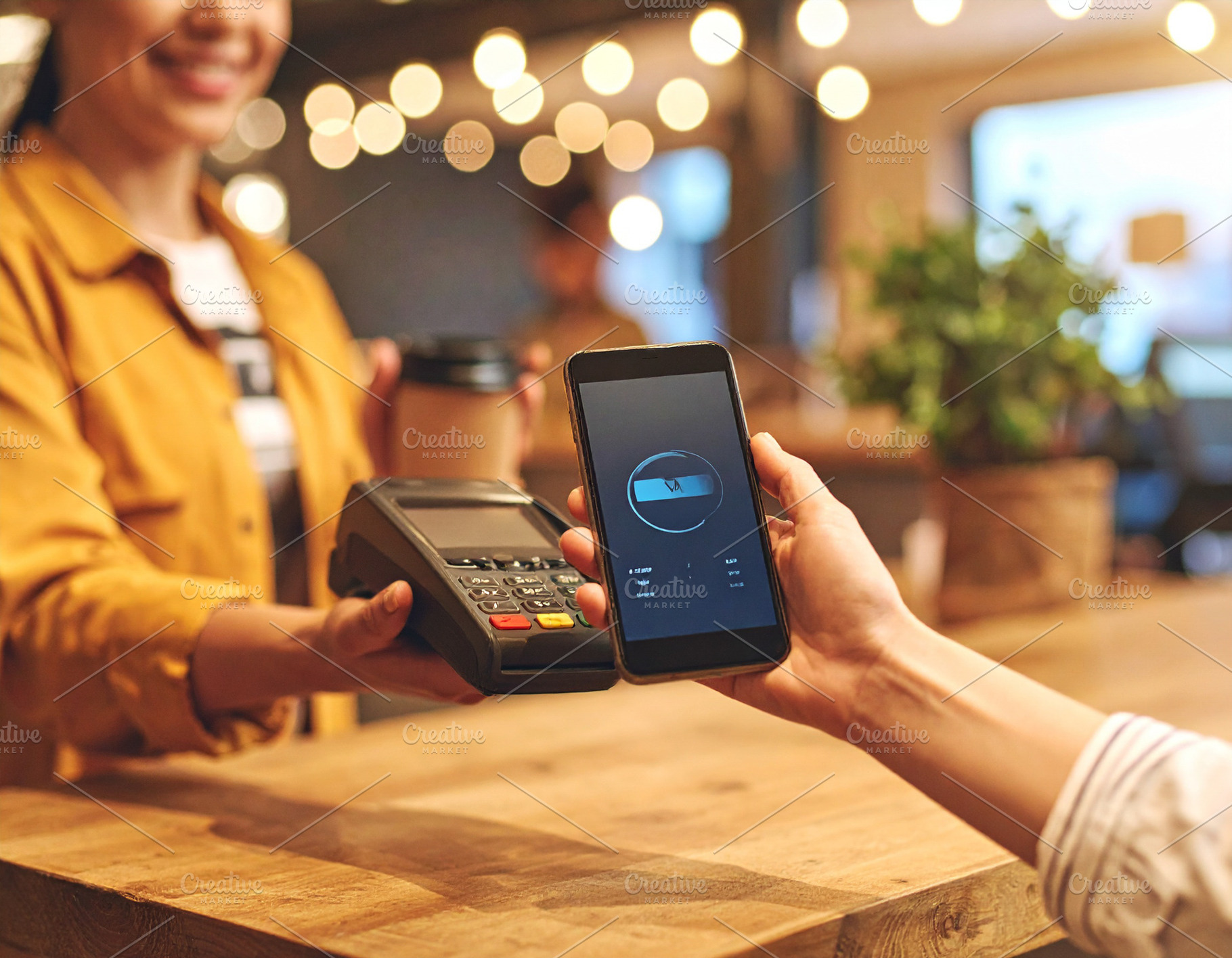 Person at a cozy café uses his smartphone to make a contactless, a Technology Photo by DanFLCreativo