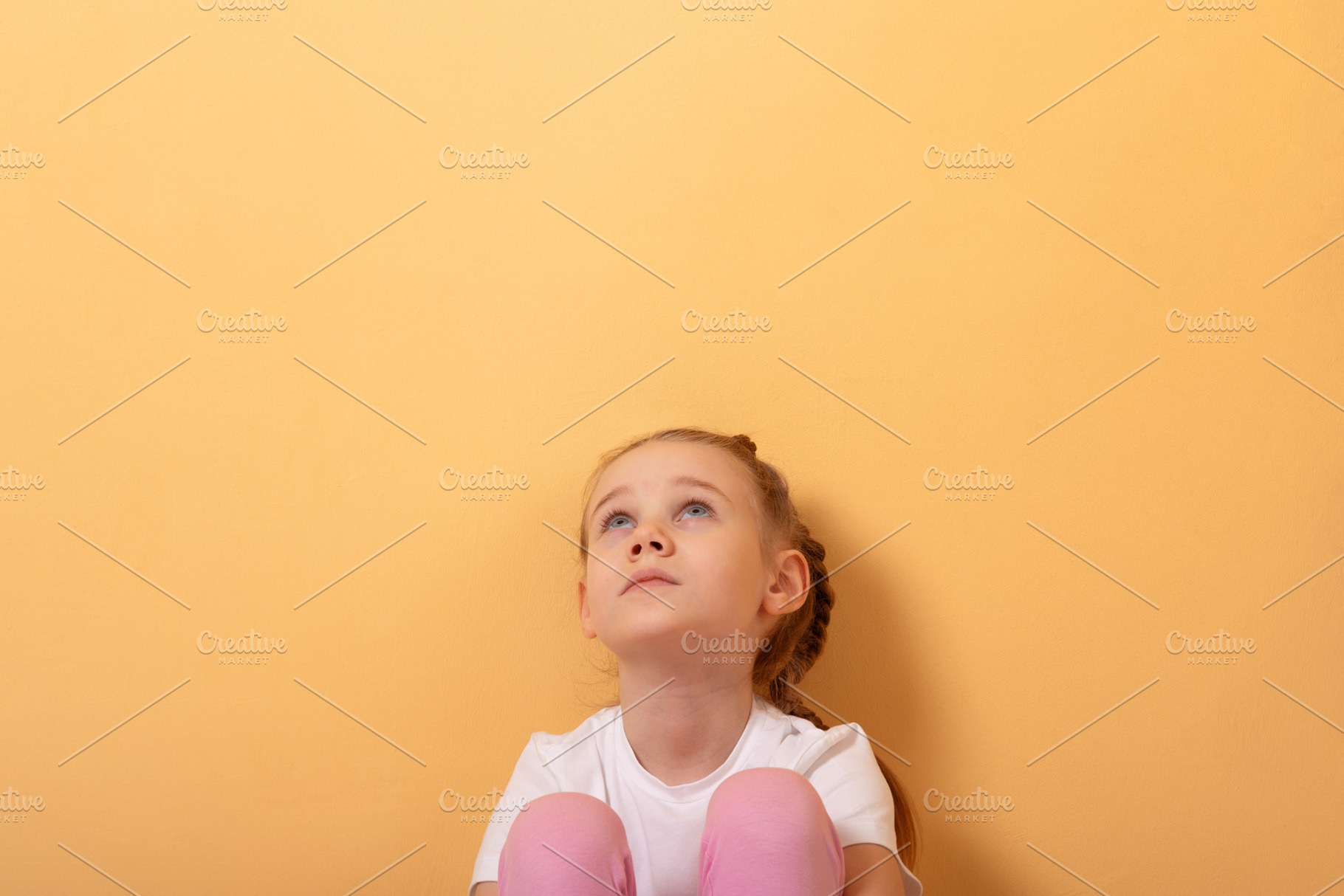 Young girl in white t-shirt and pink pants sitting and looking u, a Person Photo by Ales Munt