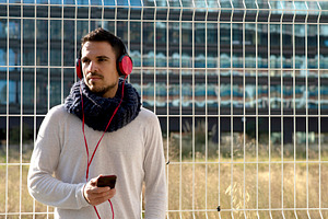 Caucasian man listening to music with smartphone outdoors, a Person Photo by RF Images