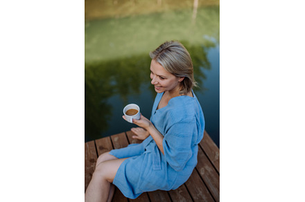Happy young woman sitting by pond, a Sports & Recreation Photo by HalfPoint