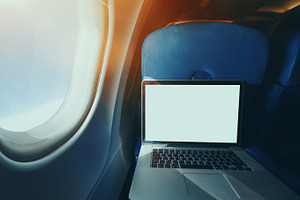 Laptop with blank screen in airplane, a Transportation Photo by SkyNext