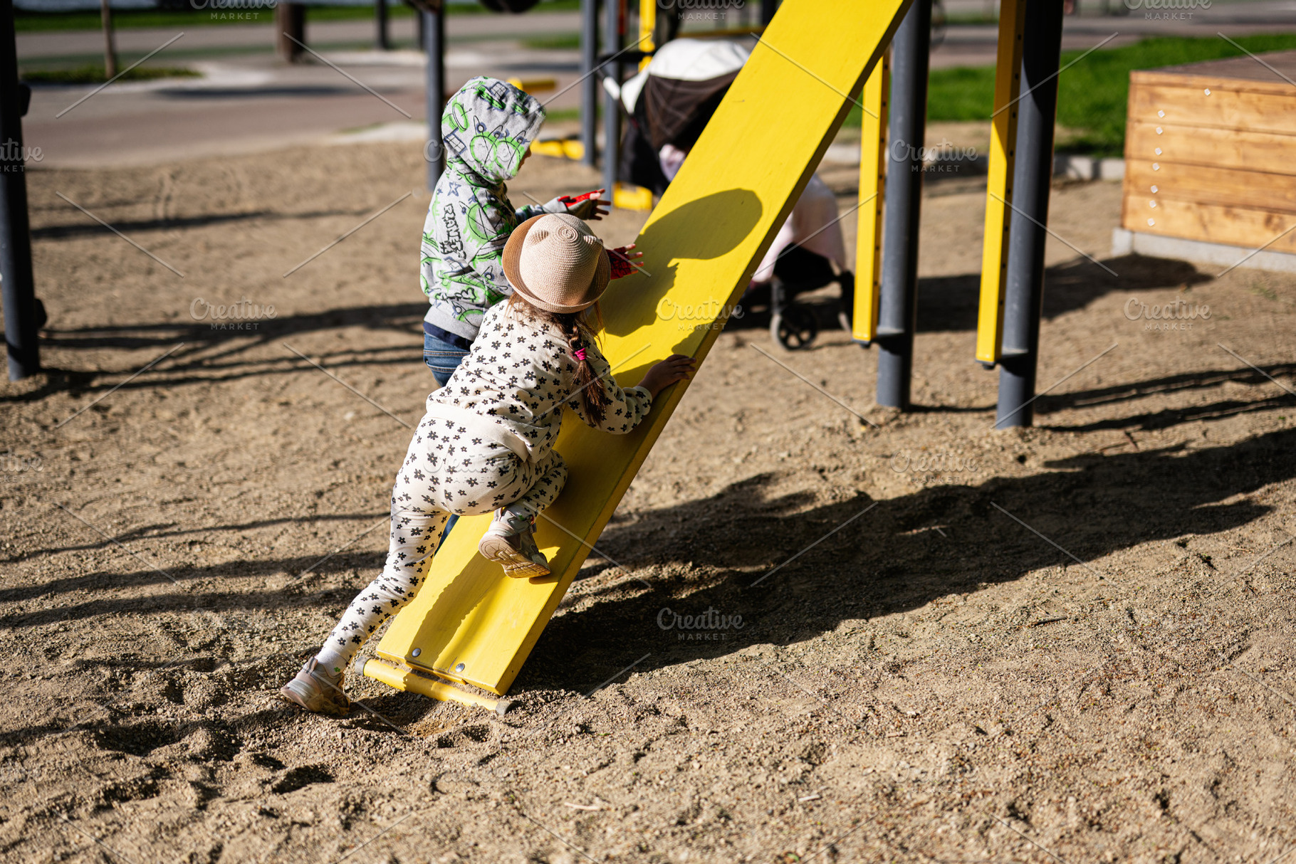 Children playing on a playground slide on a sunny day, a Person Photo by AS photostudio