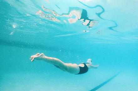 Swimming, fitness and sports with a woman underwater in a pool for cardio or endurance exercise. Water, swimwear and health with a female swimmer during a workout or competitive watersports game, a Photo by Peopleimages.com