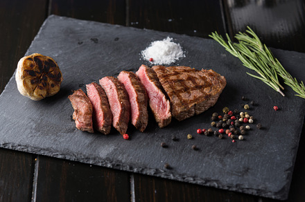 Sliced prime ribeye steak on black s stock photo containing beef and cooked