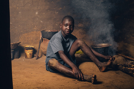 Young Boy Sits in His African Hut