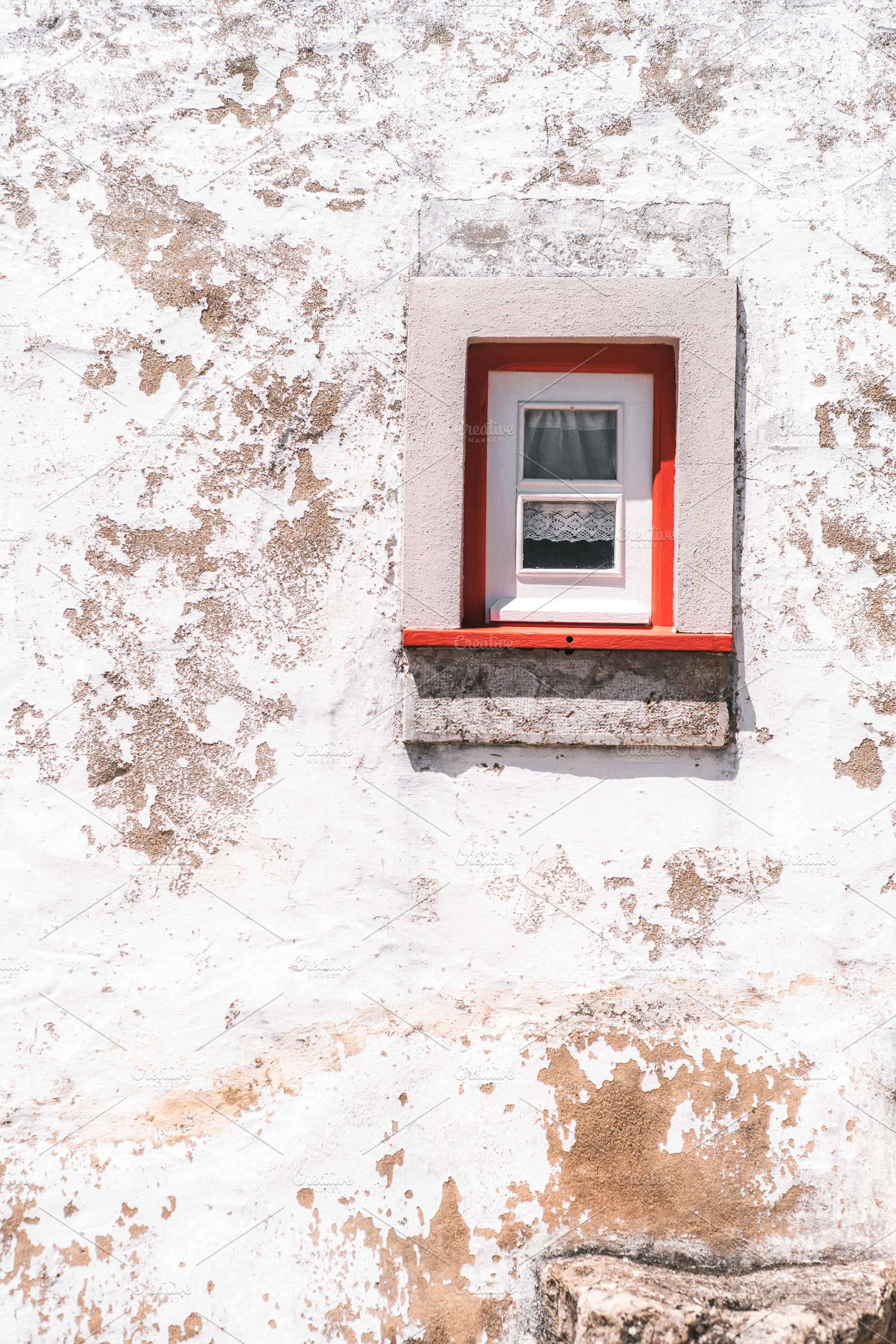 Red-trimmed window on aged wall, a Photo by SkyNext