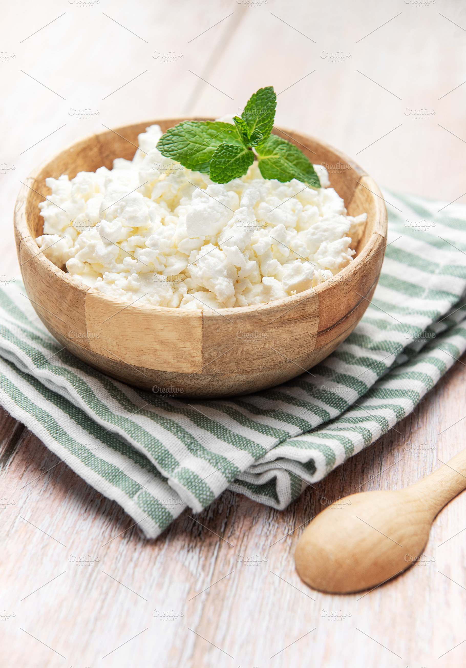 Cottage cheese in wooden bowl with mint leaf, a Food & Drink Photo by Olena Rudo