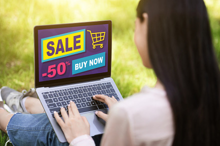Young lady resting outdoors, shopping online, using laptop, a Background Photo by Prostock-Studio
