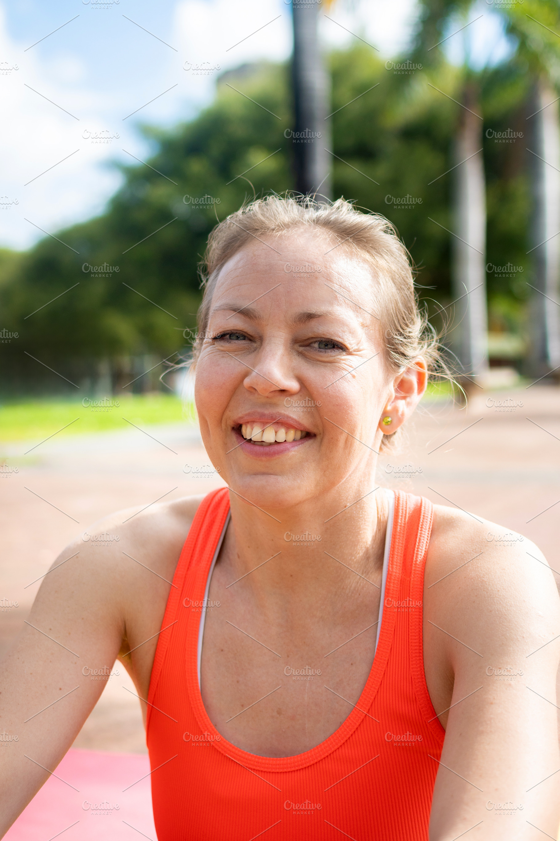 Smiling woman resting after outdoor workout in tropical park, a Sports & Recreation Photo by etorres69