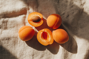Fresh apricot halves on tablecloth, a Photo by Virgo Studio