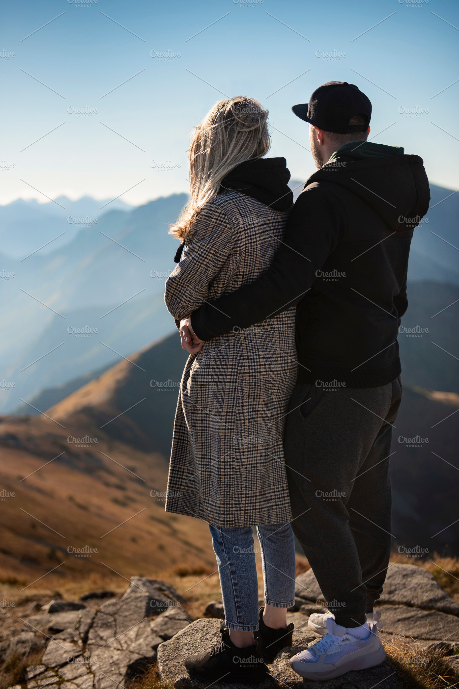 Happy couple having a break during a hiking trip in the mountain, a Sports & Recreation Photo by Olena Rudo