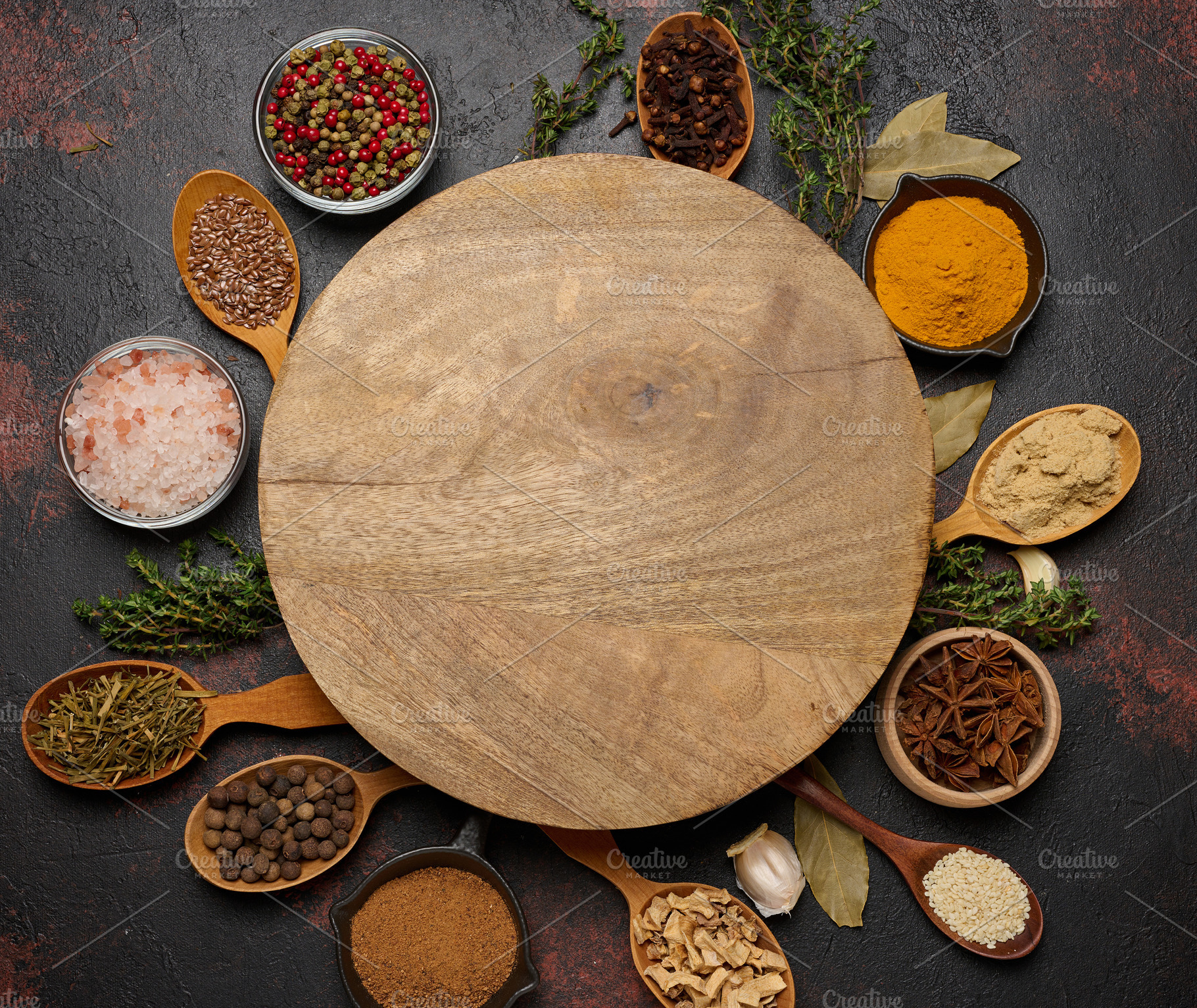 Spices around a round wooden board. Copy space, a Food & Drink Photo by ndanko